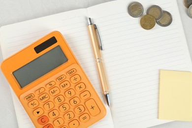 Photo of Calculator, notebook, pen, coins and sticky note on light gray table, flat lay. Retirement concept