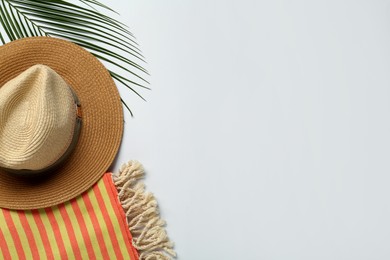 Photo of Beach towel and straw hat on light background, flat lay. Space for text