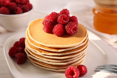 Stack of tasty pancakes with raspberries on table, closeup