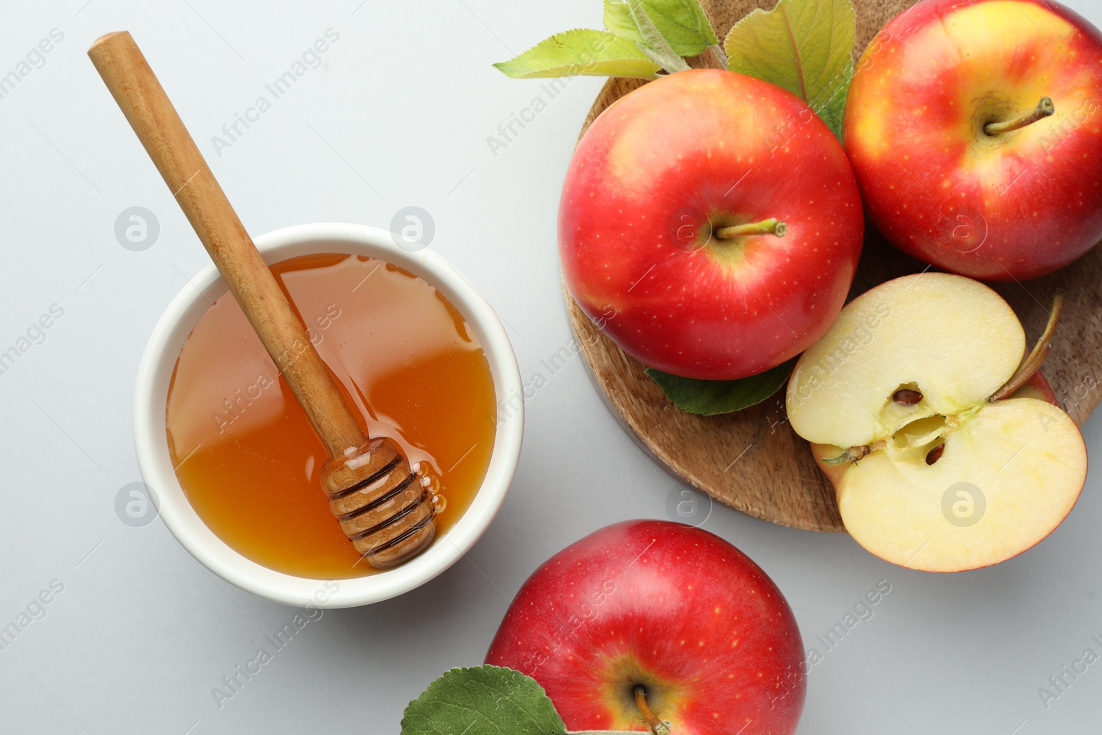 Photo of Sweet honey and fresh apples on white table, flat lay