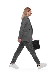 Beautiful happy businesswoman in suit with briefcase walking on white background