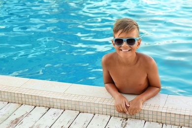 Happy cute boy with sunglasses in swimming pool