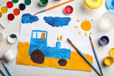 Photo of Flat lay composition with child's painting of tractor on white wooden table