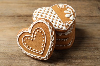 Photo of Tasty heart shaped gingerbread cookies on wooden table, closeup