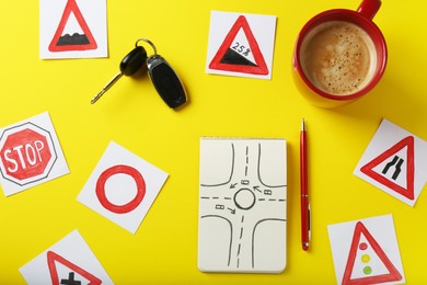 Photo of Flat lay composition with workbook for driving lessons and road signs on yellow background. Passing license exam