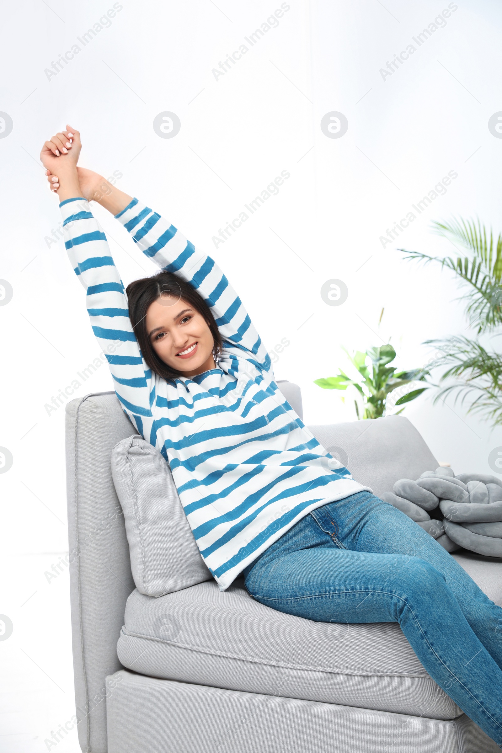 Photo of Young woman relaxing on couch at home