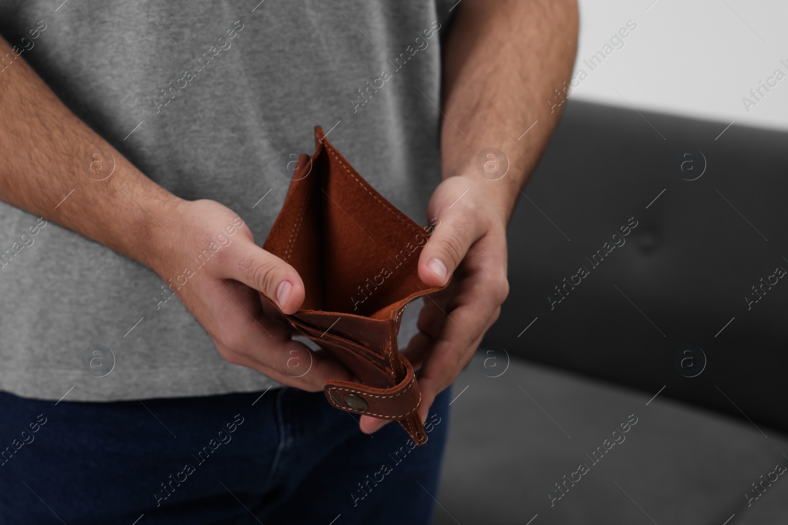 Photo of Man with empty wallet at home, closeup