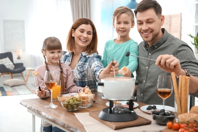 Photo of Happy family enjoying fondue dinner at home