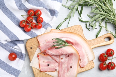 Photo of Flat lay composition with sliced raw bacon on light grey marble table