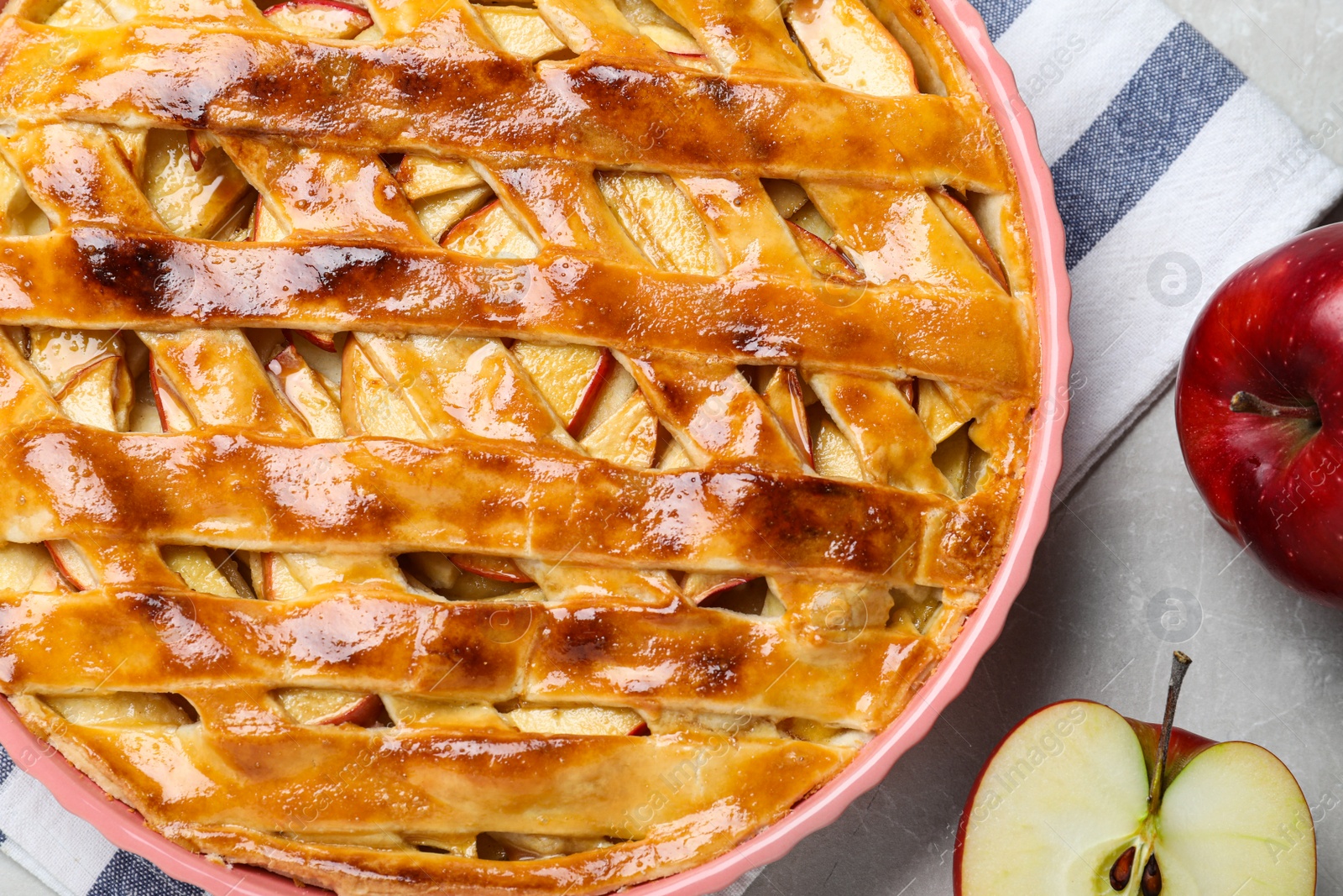 Photo of Traditional apple pie and fruits on light grey table, flat lay