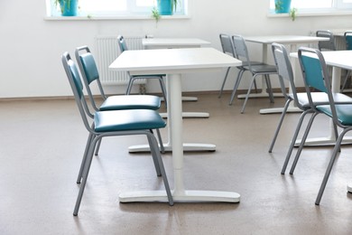 Photo of Empty school classroom with desks and chairs