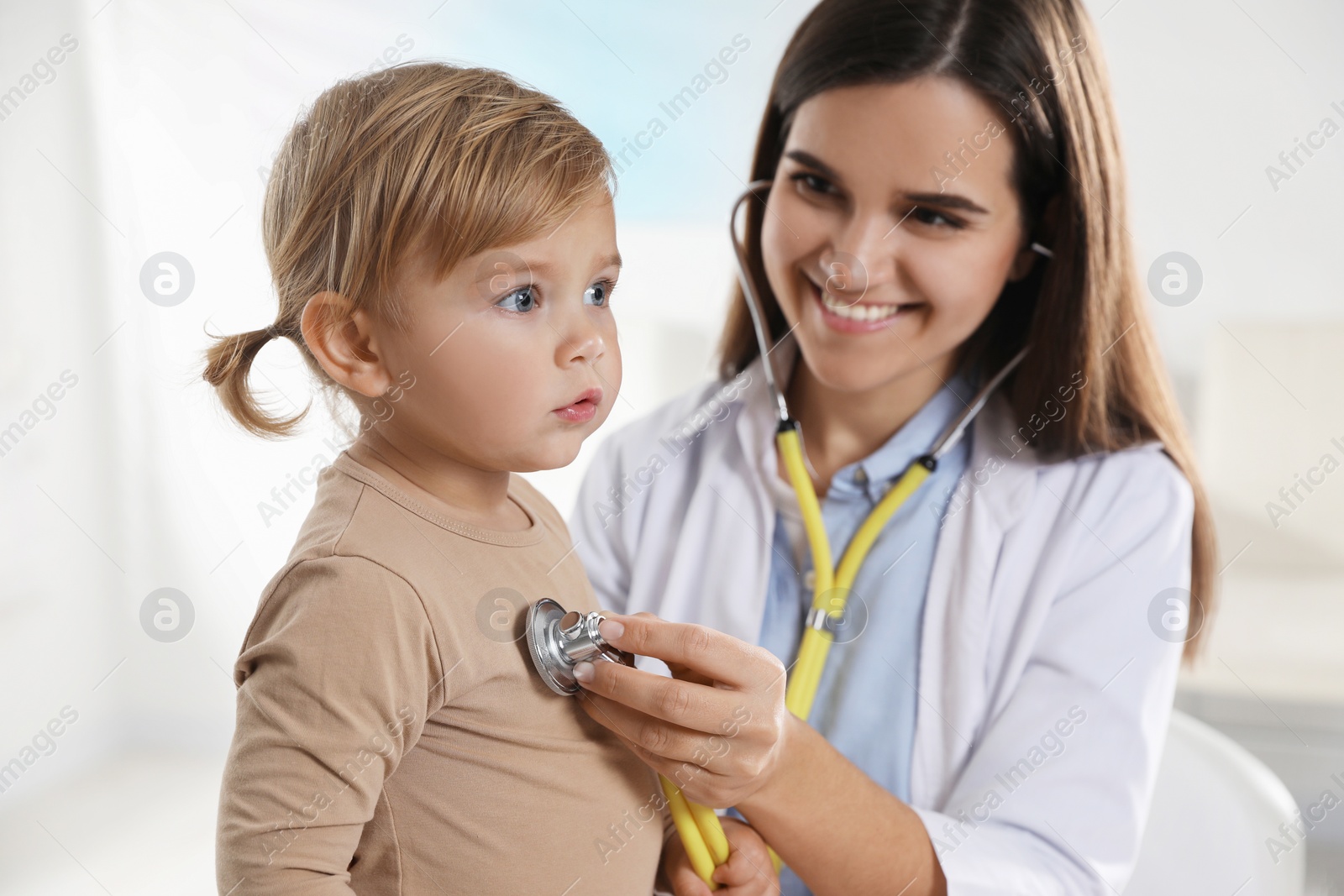 Photo of Pediatrician examining baby with stethoscope in clinic