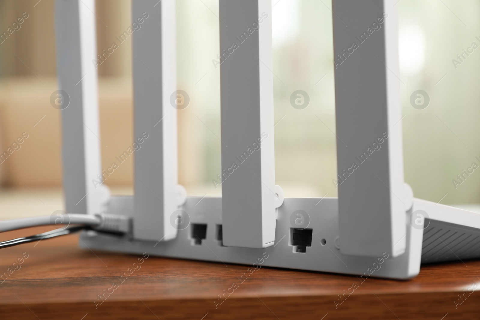 Photo of New modern Wi-Fi router on wooden table indoors, closeup