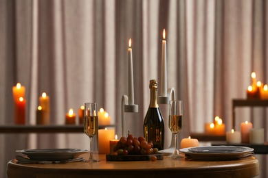 Festive table setting with burning candles indoors