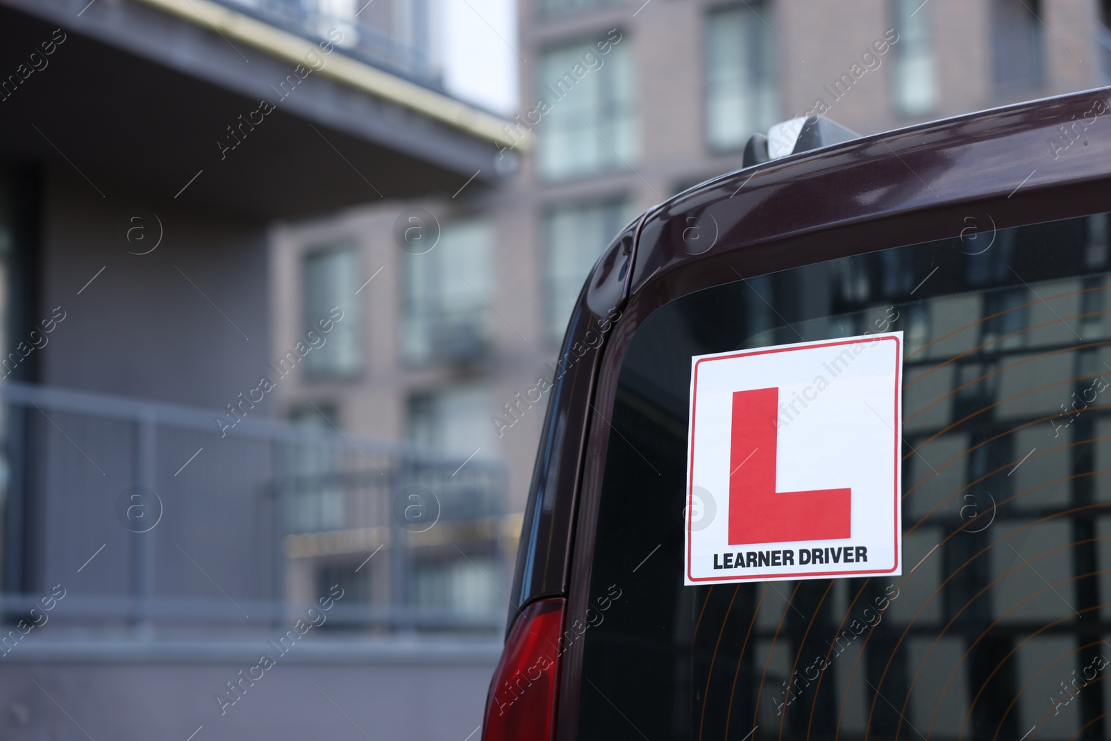 Photo of L-plate on car outdoors, closeup with space for text. Driving school