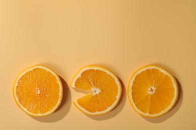 Photo of Slices of juicy orange on beige background, flat lay. Space for text
