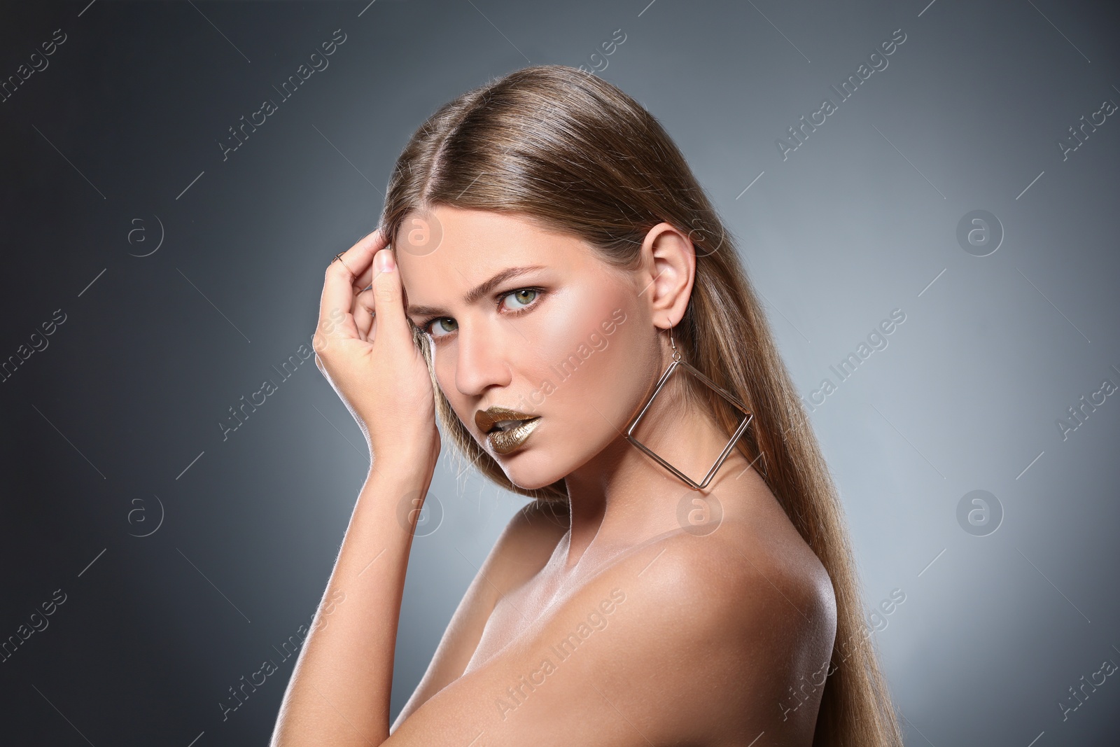 Photo of Portrait of beautiful lady with gold lipstick on grey background