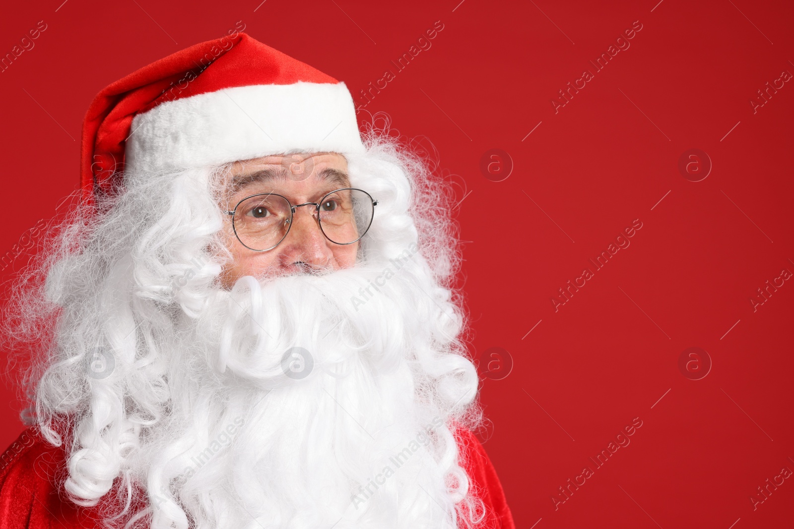 Photo of Merry Christmas. Santa Claus posing on red background. Space for text