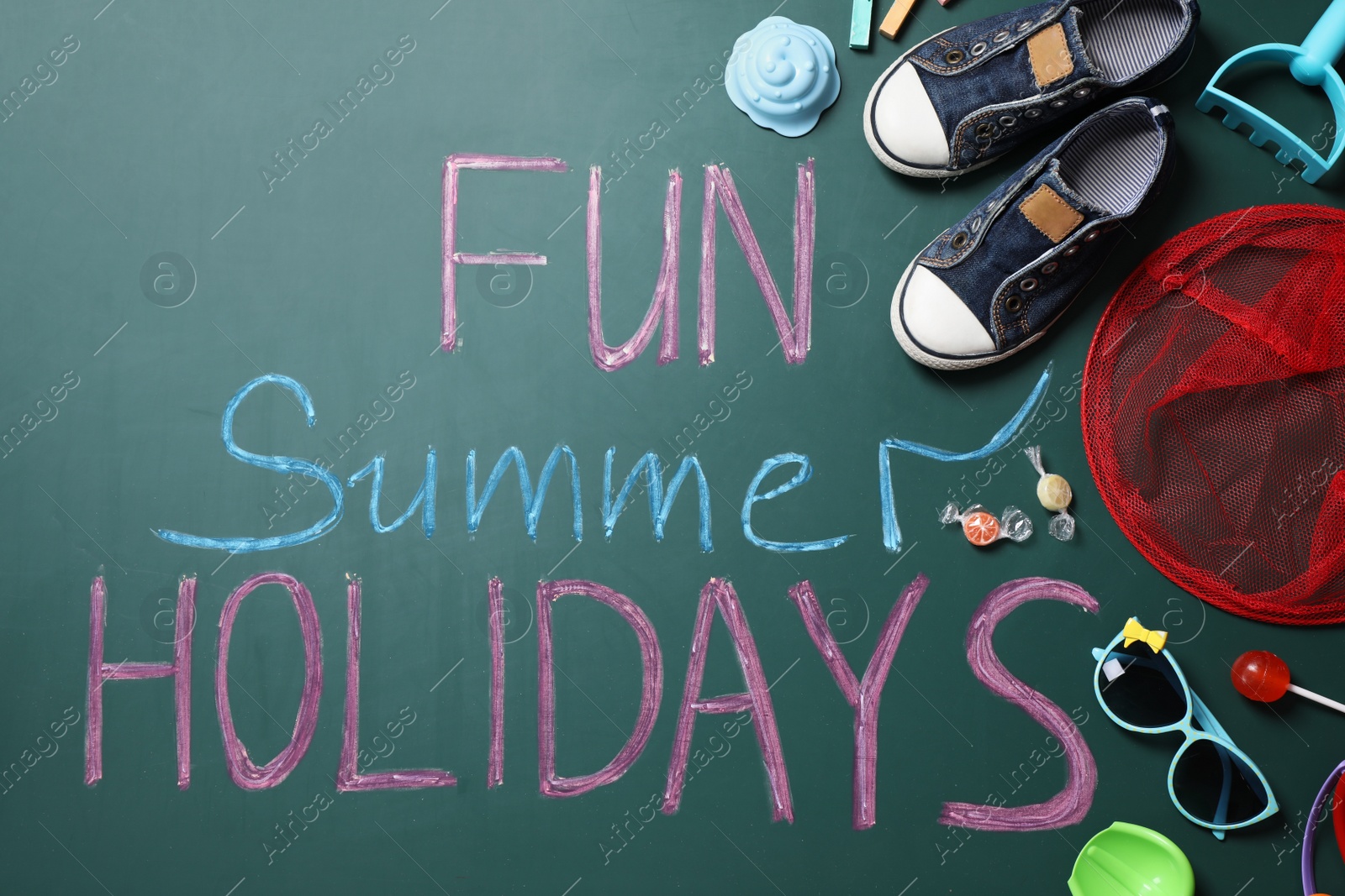 Photo of Different child accessories and text Fun Summer Holidays on school chalkboard, flat lay