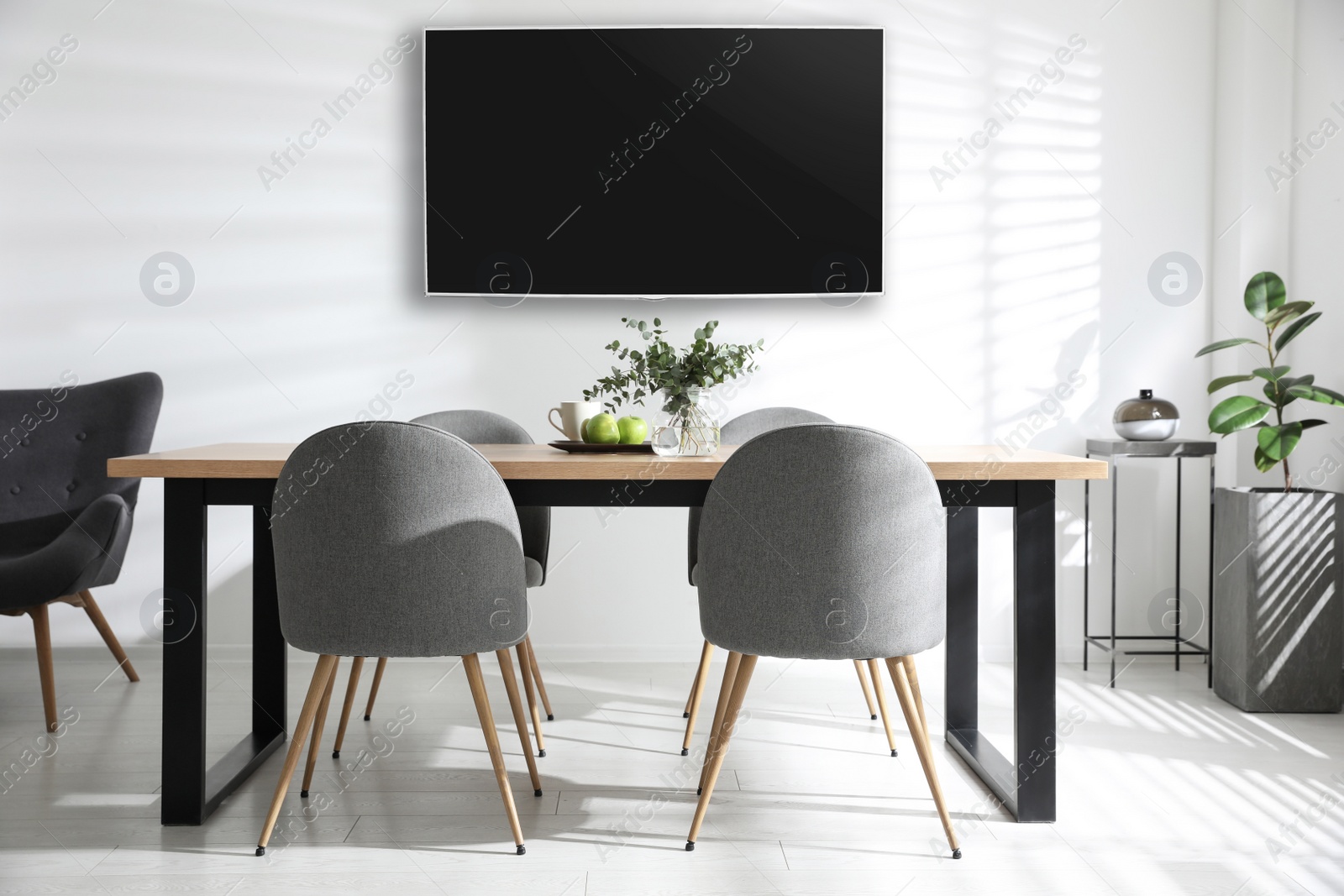 Image of Modern wide screen TV on white wall in room with stylish furniture 