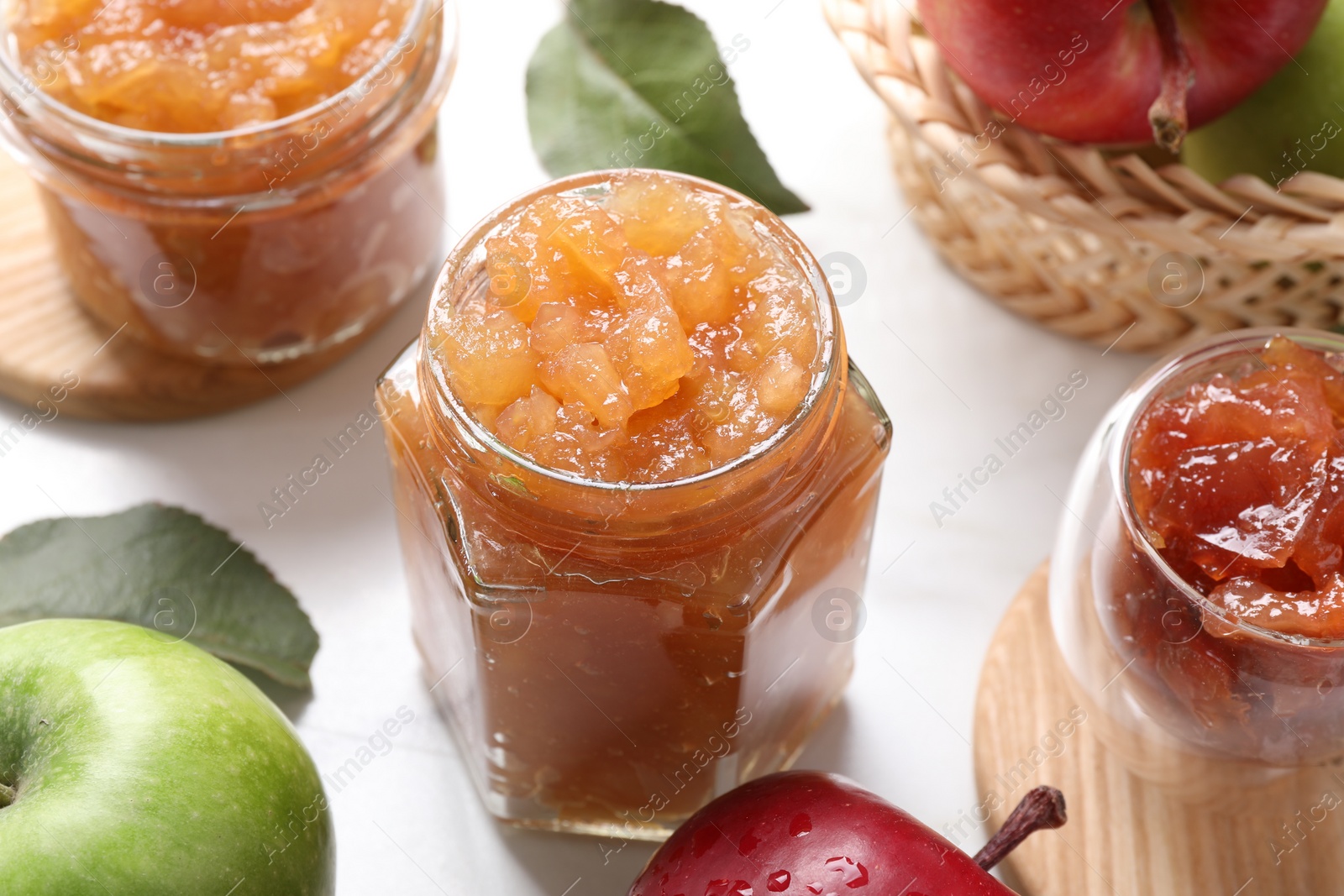 Photo of Delicious apple jam and fresh fruits on white table, closeup