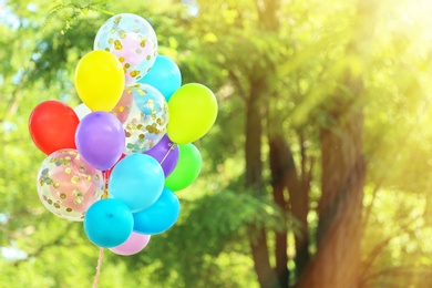 Photo of Many colorful balloons outdoors on sunny day