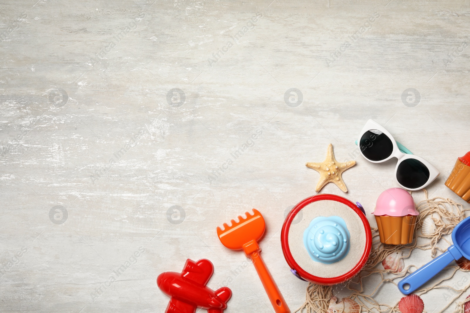 Photo of Flat lay composition with beach toys on light background. Space for text