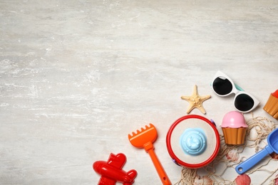 Flat lay composition with beach toys on light background. Space for text