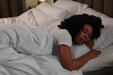 Young woman sleeping in soft bed at night