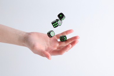 Woman throwing game dices on white background, closeup