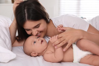 Photo of Happy young mother with her cute baby on bed at home