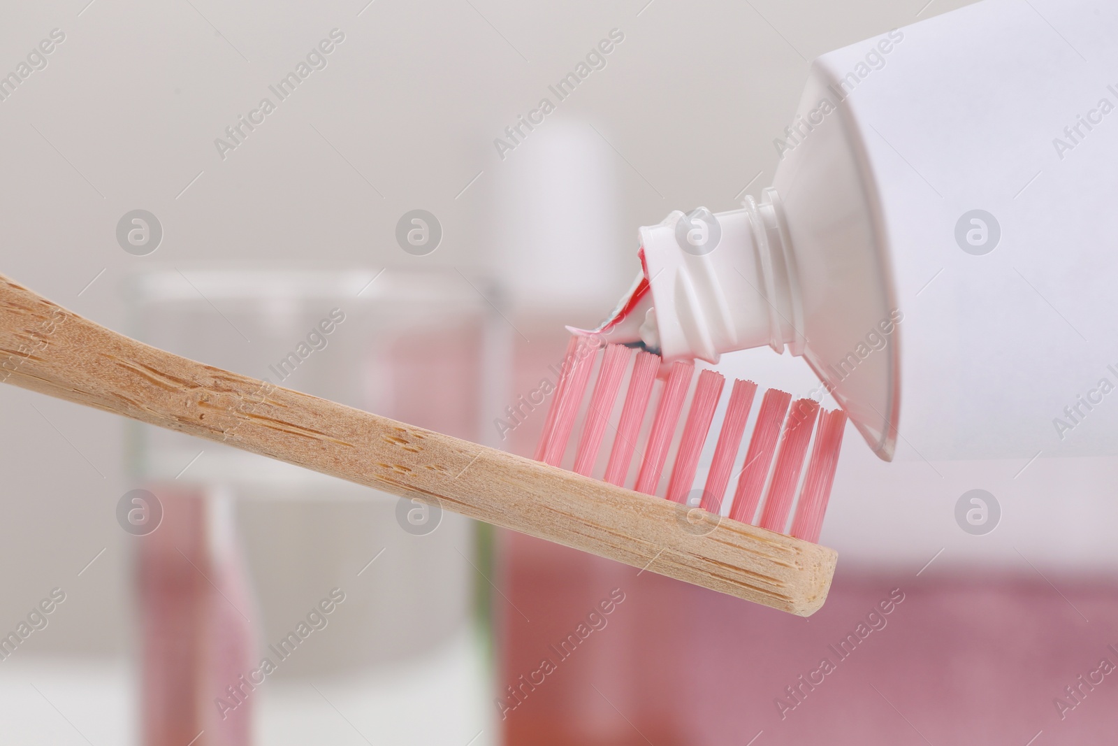 Photo of Applying paste on toothbrush near mouthwash, closeup