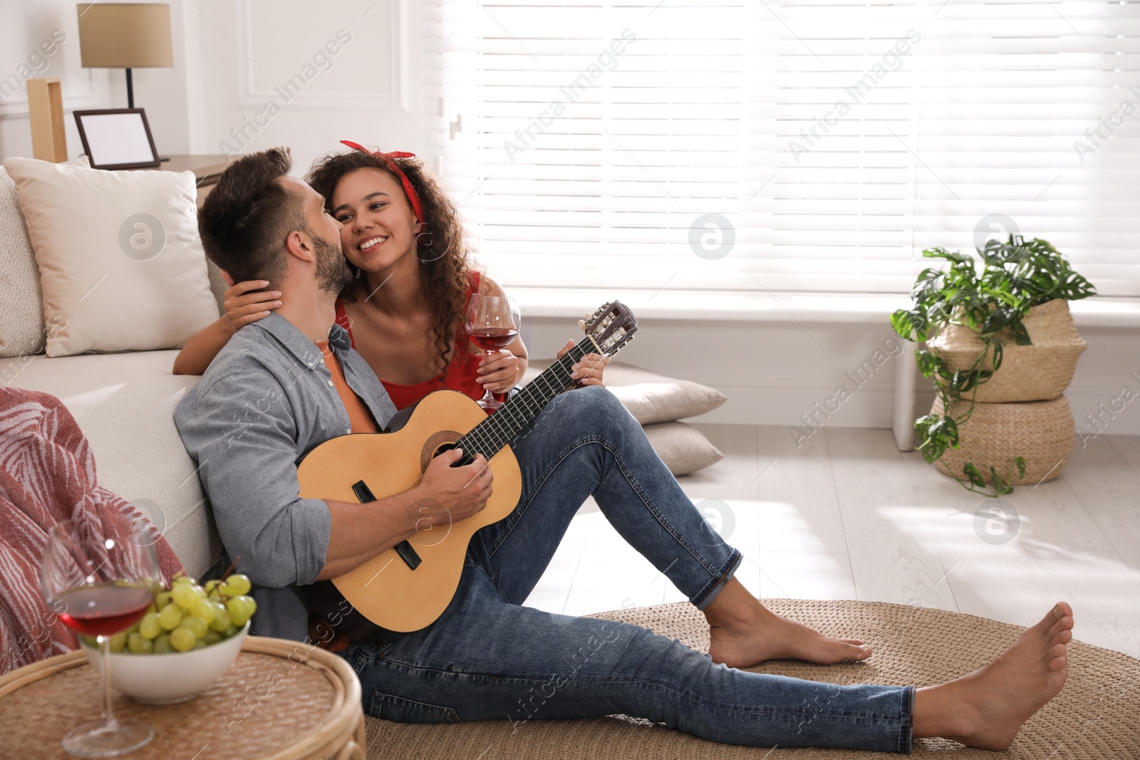 Photo of Lovely couple with guitar spending time together at home