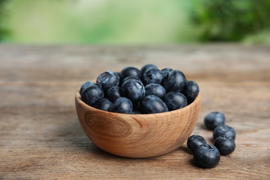 Bowl of fresh blueberries on wooden table