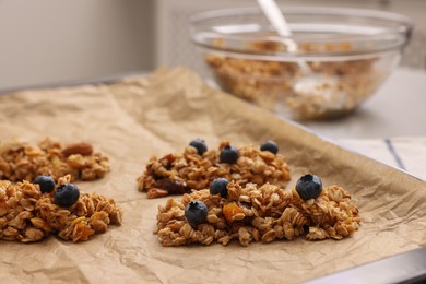 Photo of Different granola bars on parchment paper, closeup. Healthy snack
