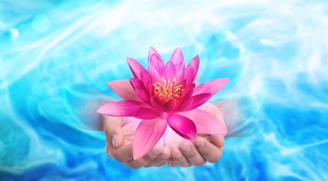 Image of Man holding beautiful lotus flower on bright background, closeup