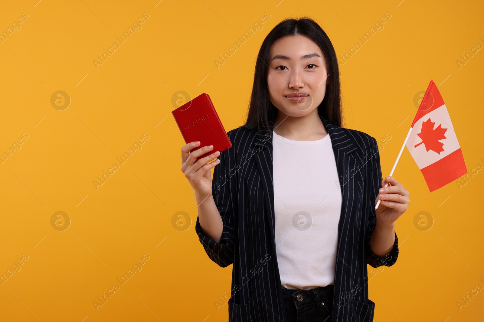 Photo of Immigration to Canada. Woman with passport and flag on orange background, space for text