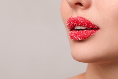 Young woman with beautiful lips covered in sugar, on light background, closeup. Space for text