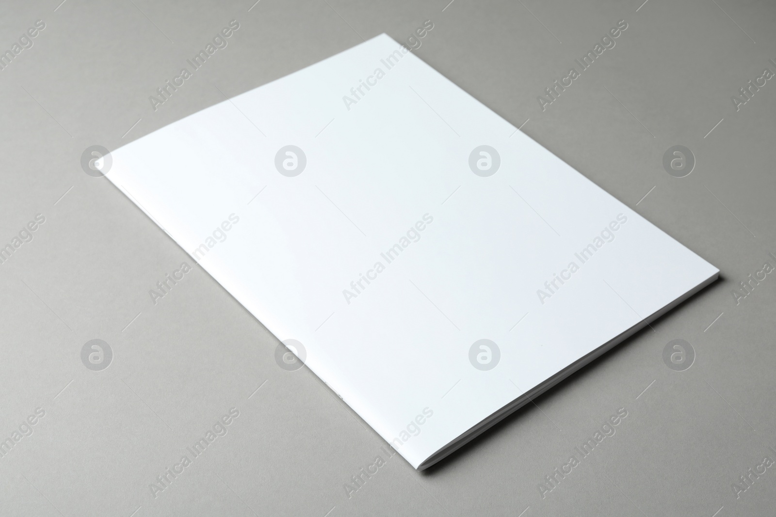 Photo of Brochure with blank cover on grey background. Mock up for design