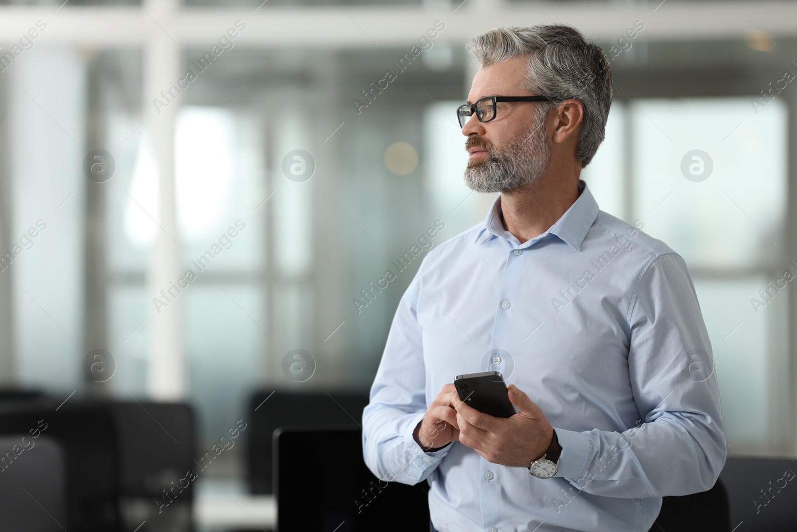 Photo of Handsome man with smartphone in office, space for text. Lawyer, businessman, accountant or manager