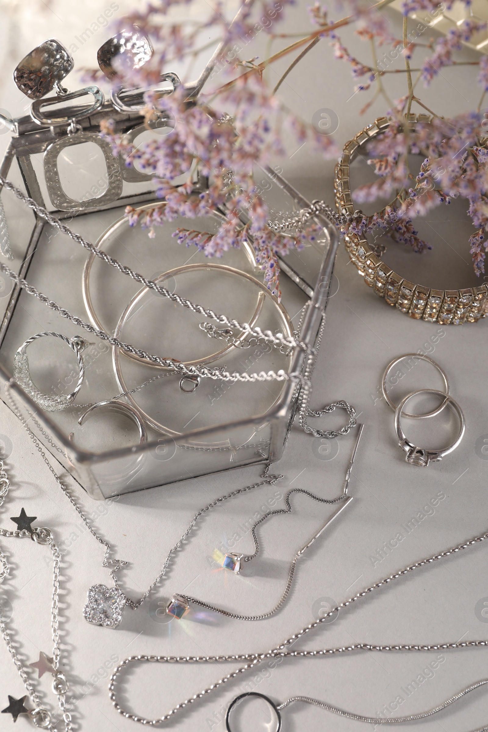Photo of Metal chains and other different accessories on light table, above view. Luxury jewelry