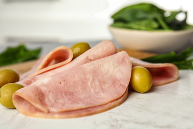 Photo of Ham with olives and spinach on table, closeup