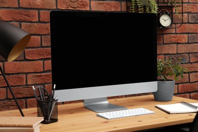 Photo of Cozy workplace with computer and stationery on desk. Home office