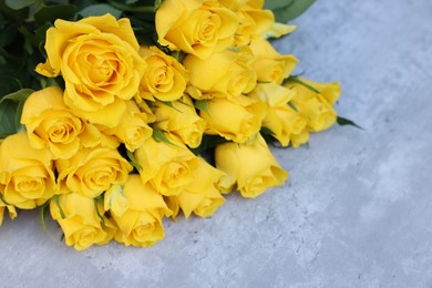 Photo of Beautiful bouquet of yellow roses on light table, above view. Space for text