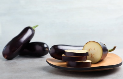 Photo of Wooden board with ripe eggplants on table