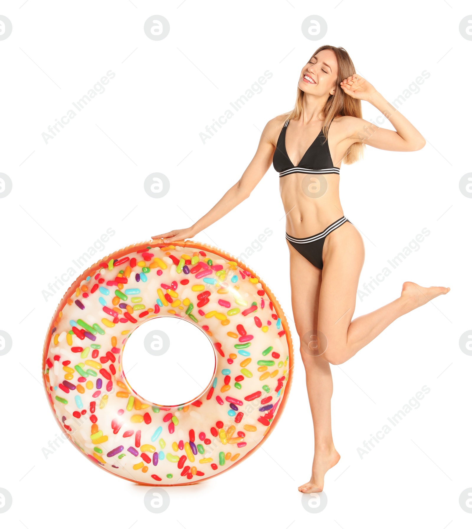 Photo of Beautiful young woman in stylish bikini with doughnut inflatable ring on white background