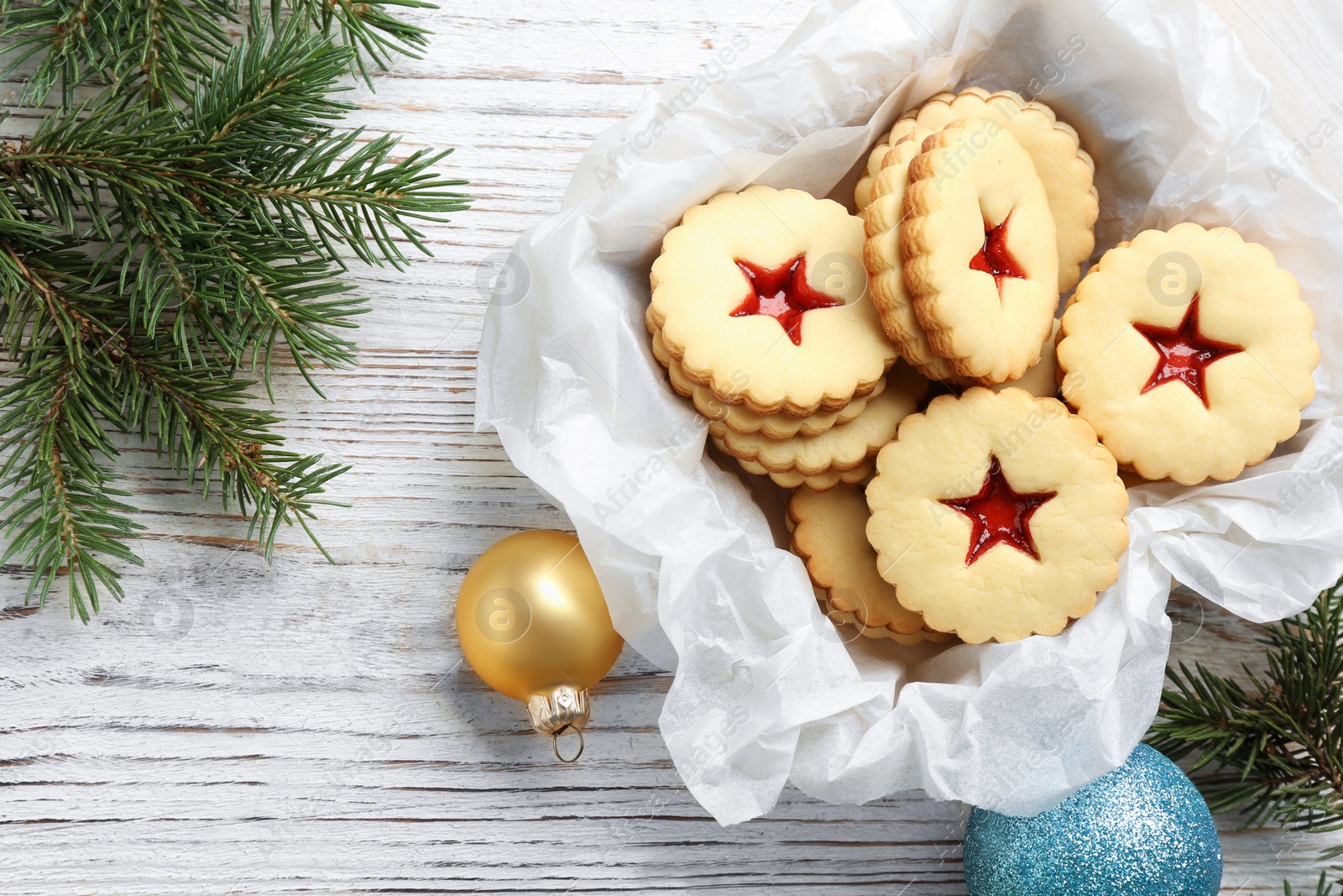 Photo of Traditional Christmas Linzer cookies with sweet jam in wooden crate on table, top view