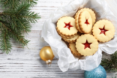 Photo of Traditional Christmas Linzer cookies with sweet jam in wooden crate on table, top view