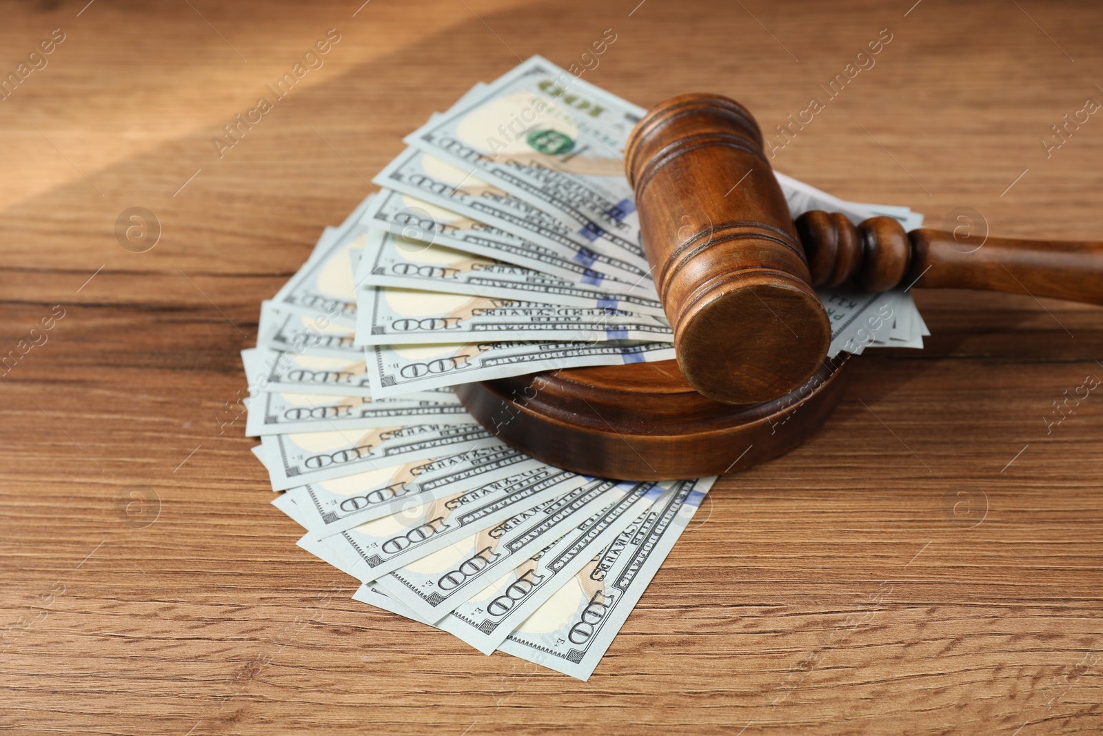 Photo of Judge's gavel and money on wooden table