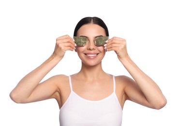 Photo of Beautiful young woman putting green tea bags on eyes against white background